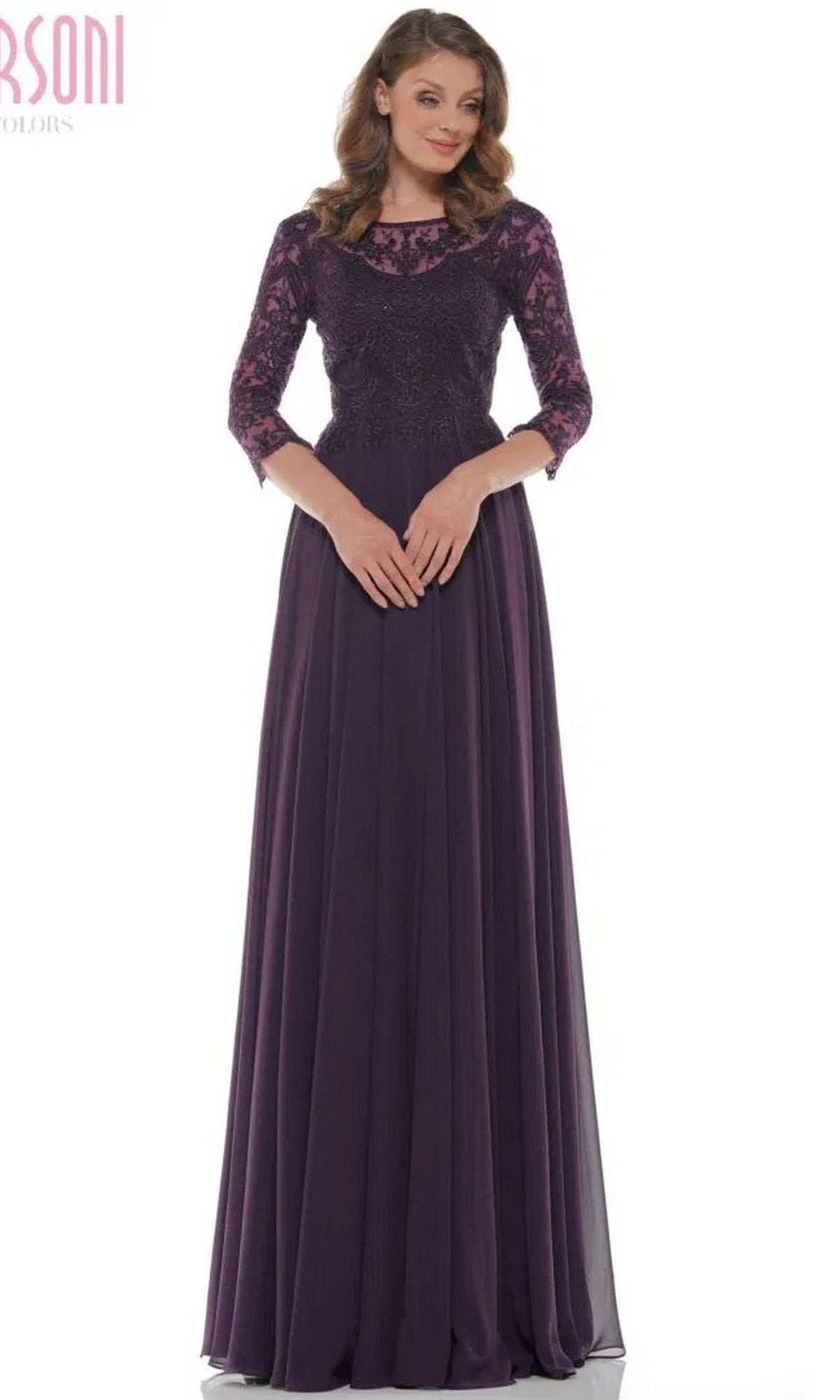 A woman stands against a white background wearing the Marsoni M238SL long formal dress in eggplant, featuring three-quarter sleeves, lace detailing, a beaded bodice, and a flowing chiffon A-line skirt.